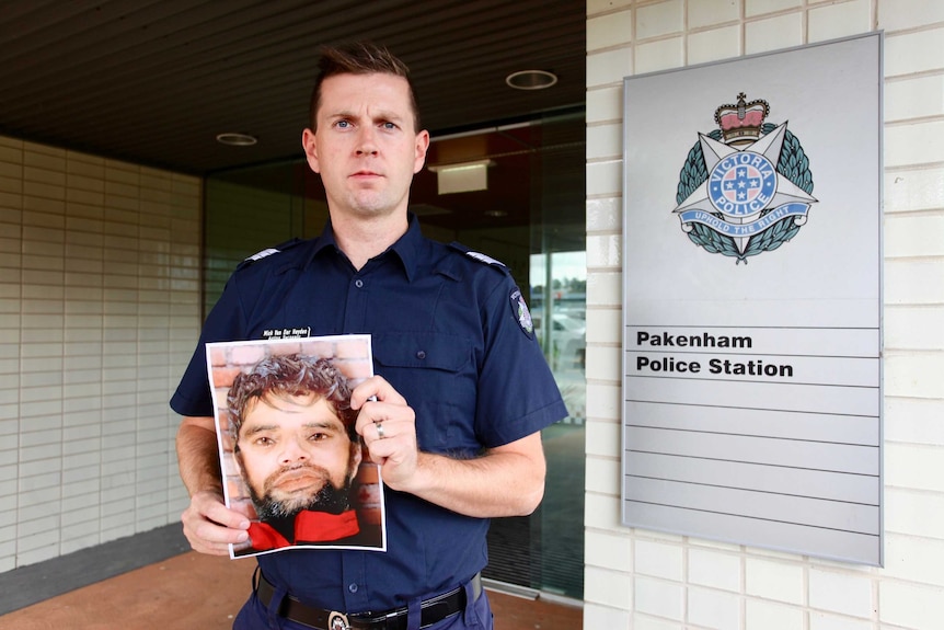 Acting Sergeant Mick Van Der Heyden holds an image of the Pakenham man.