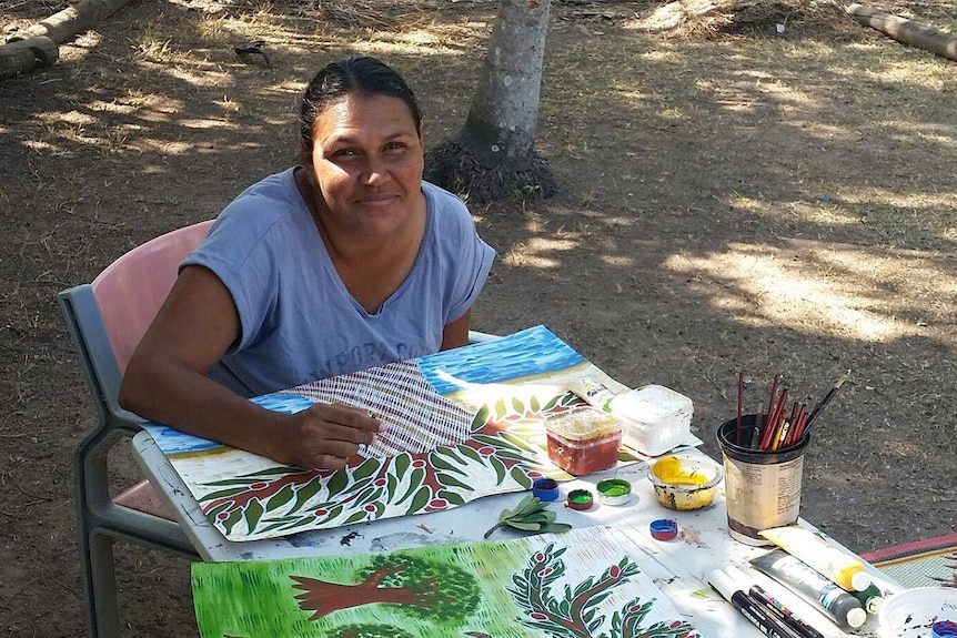 woman painting outside on a table