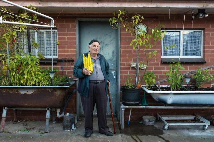 Man in yard holding vegetables