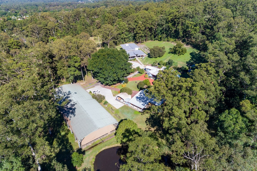 Aerial photo of buildings and structures amid thick bushland.
