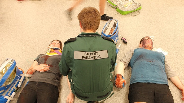 A student paramedic attends to the 'injured' in the casualty clearing station