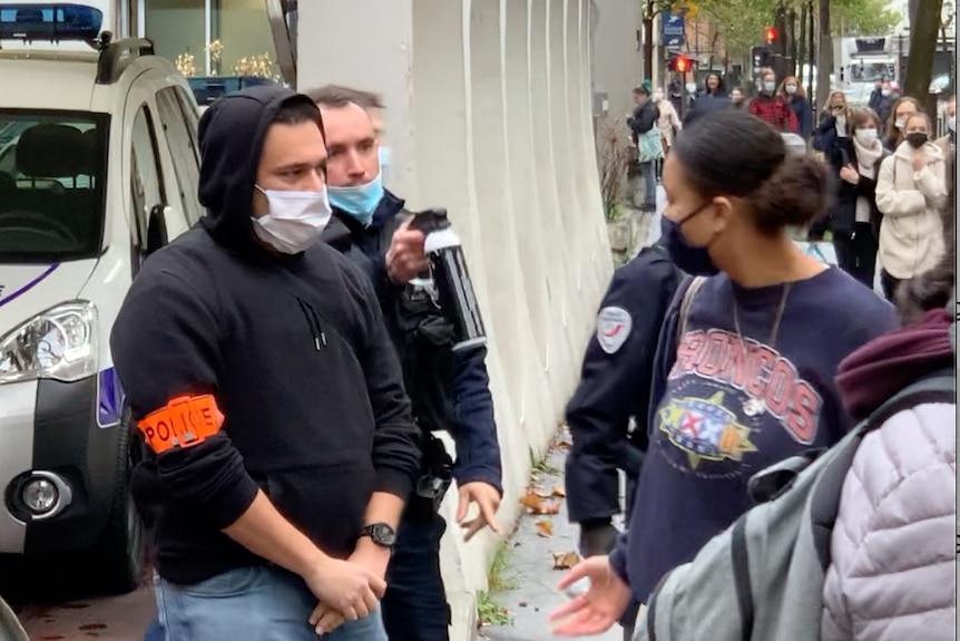 A police officer points pepper spray at a woman.