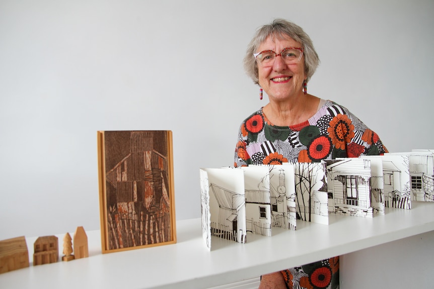 A woman and her artwork in a gallery