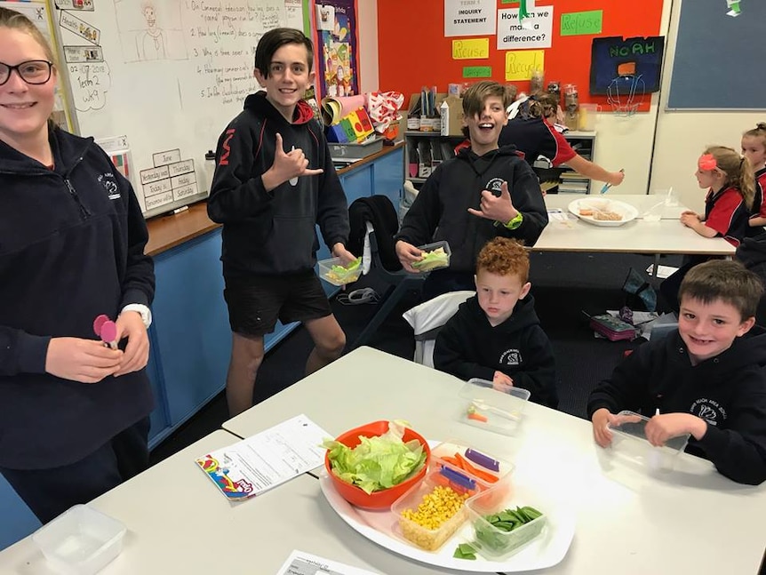 Swan Reach Primary School students in a class room with fresh food such as salad, corn and carrots.