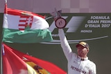 Lewis Hamilton raises trophy celebrating