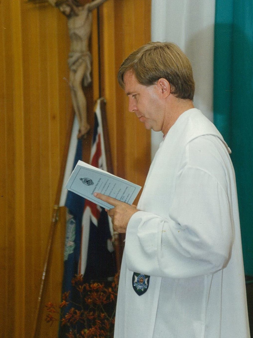 Father Michael Lowcock holding a sermon in the Mount Isa parish, dressed in white robes.