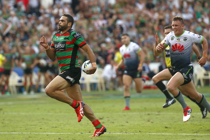Greg Inglis runs with the ball while a Raiders defender chases
