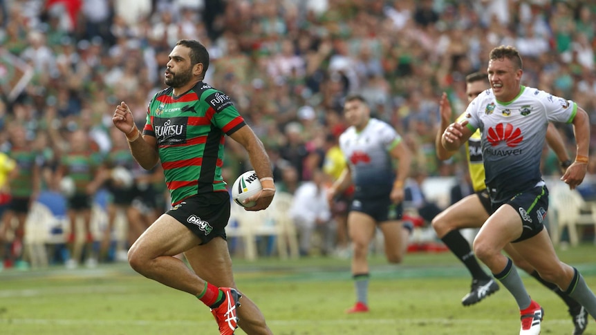Greg Inglis runs with the ball while a Raiders defender chases
