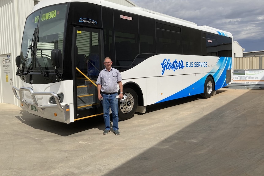 Driver standing by his bus