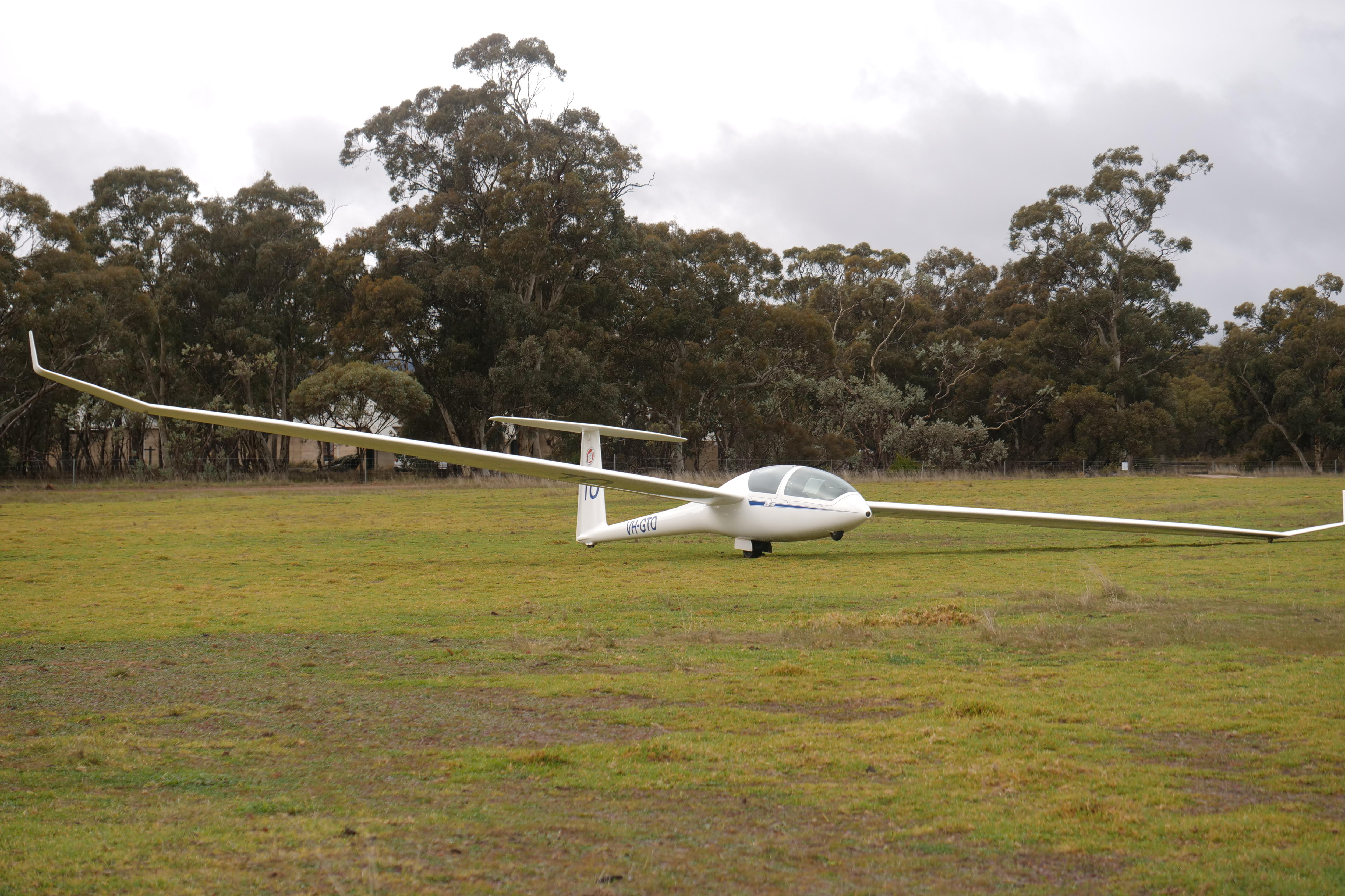 A small white plane sits on grass.