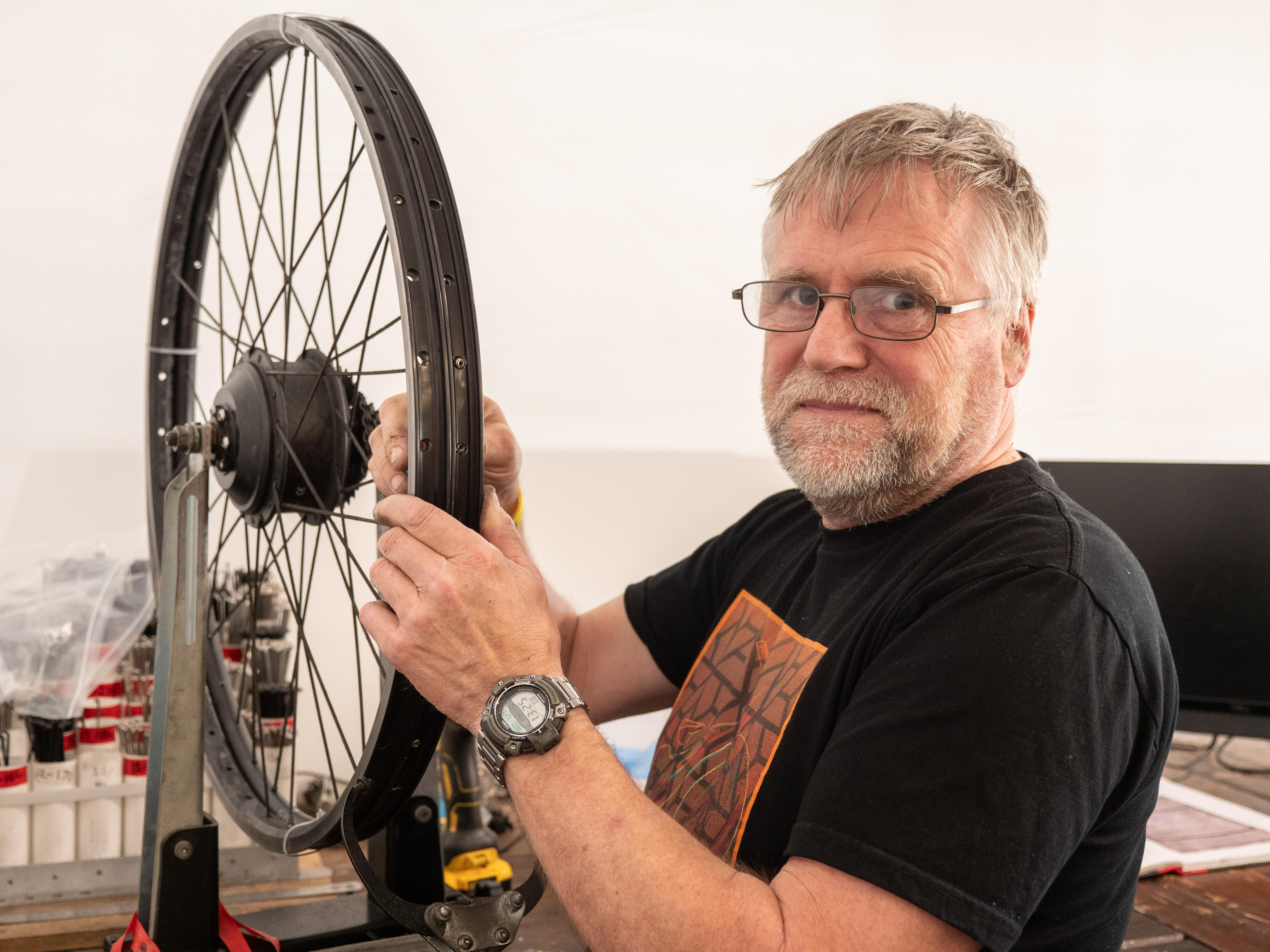 Henry Shiel repairs an e-bike wheel