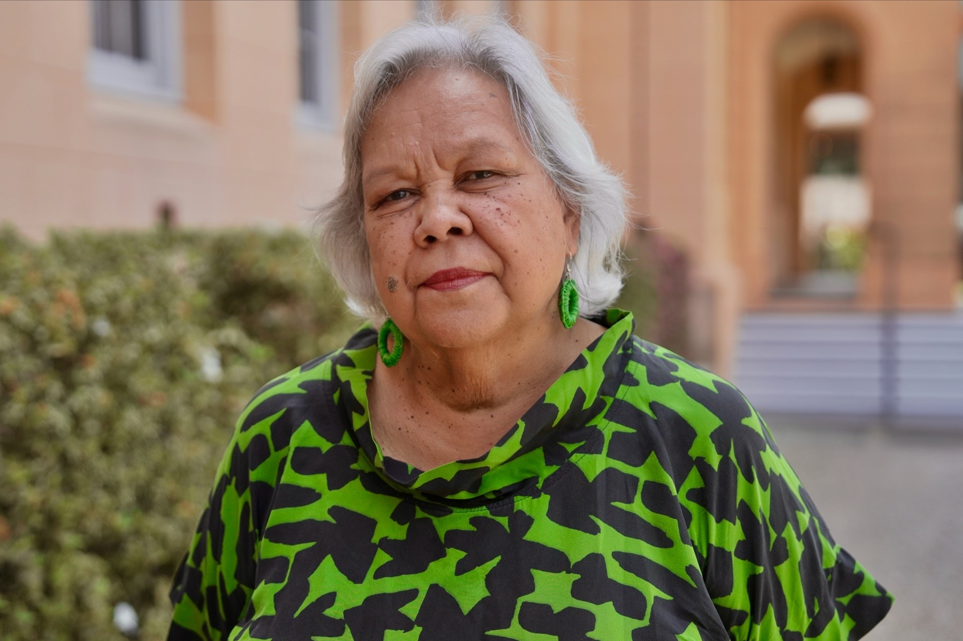 An older woman in a green and black top