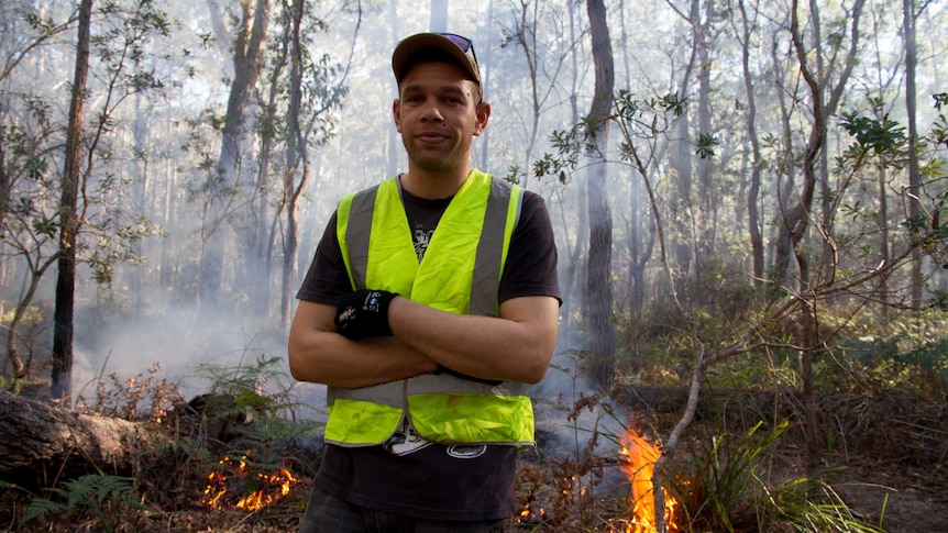 Cultural burn crew member standing at site of burn