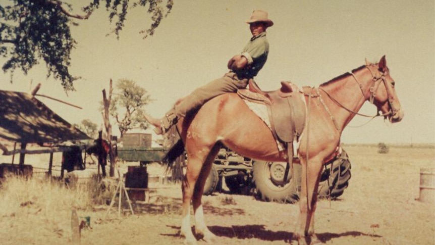 a man sitting on the back of a horse.