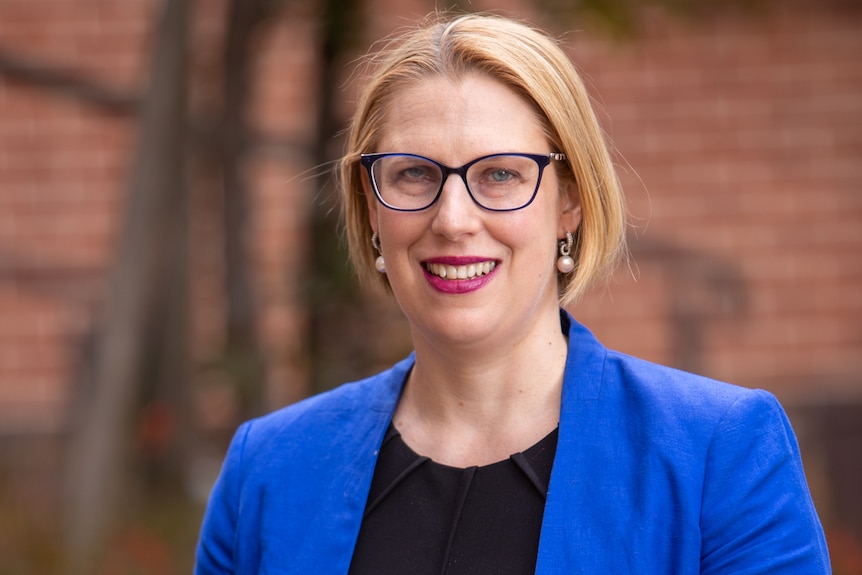 A woman smiles at the camera