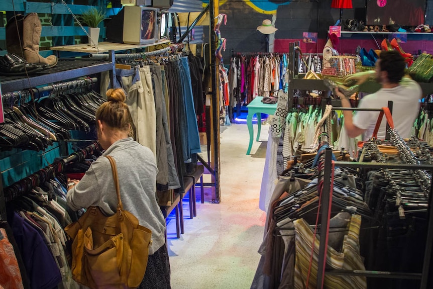 Clothes on racks inside the op shop.