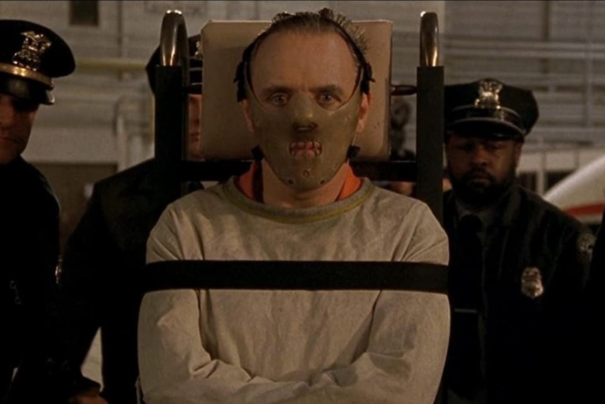 Anthony Hopkins, acting as Hannibal Lecter, wears a straight jacket and a mask keeping his mouth closed