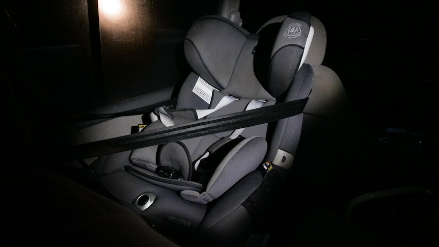 An empty child seat sits in the back of a vehicle. 