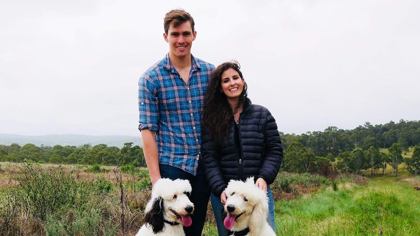 Brady (last name withheld) and Charlotte Brierley with their two dogs on their property in Queensland's Granite Belt.