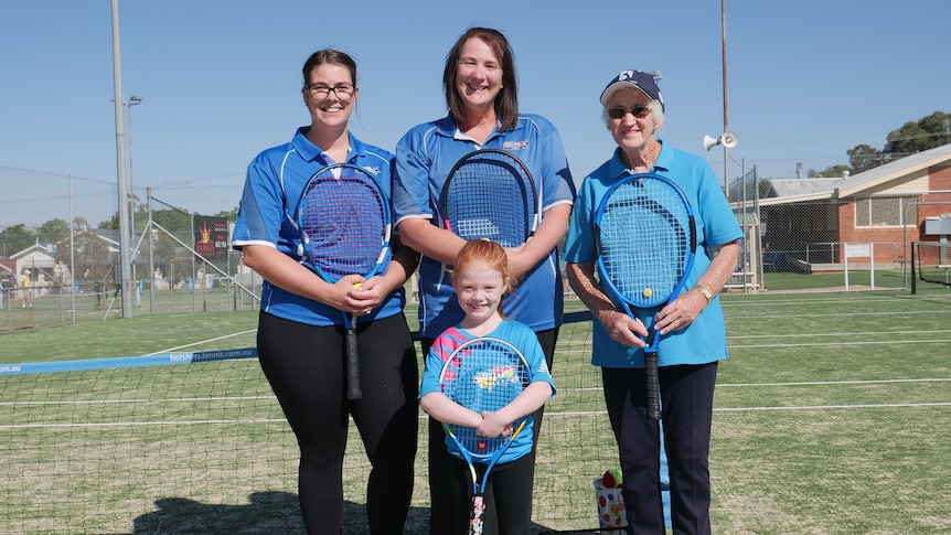 Four women holding tennis rackets 