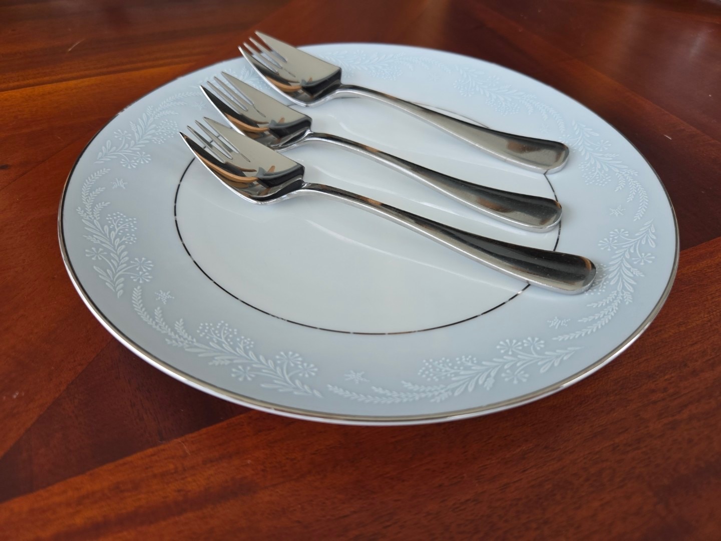 Tres platos de plata descansan sobre un plato. 