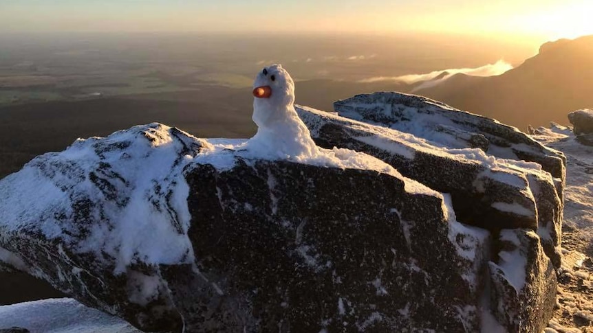 A carrot-nosed snowman at Bluff Knoll in WA's Great Southern with the sun behind it.