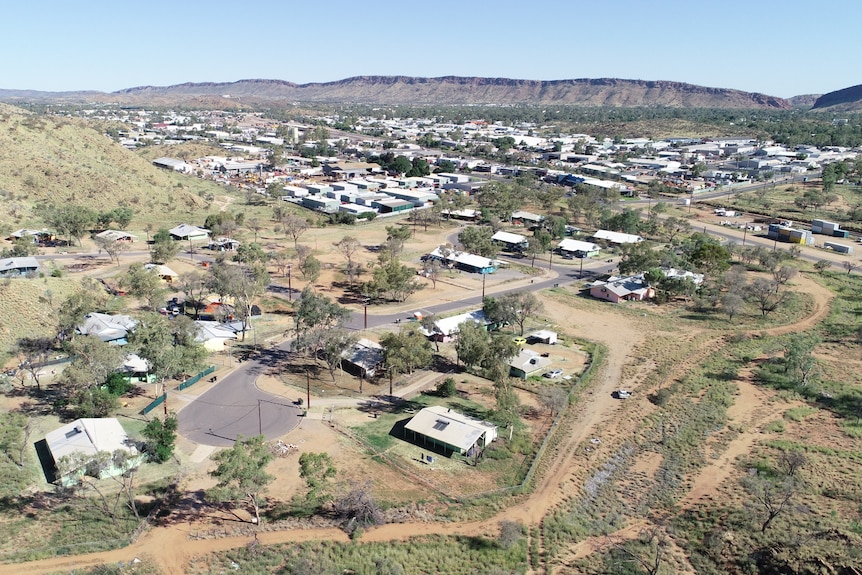 An aerial view of the Alice Springs township and its town camps, on a sunny day. 