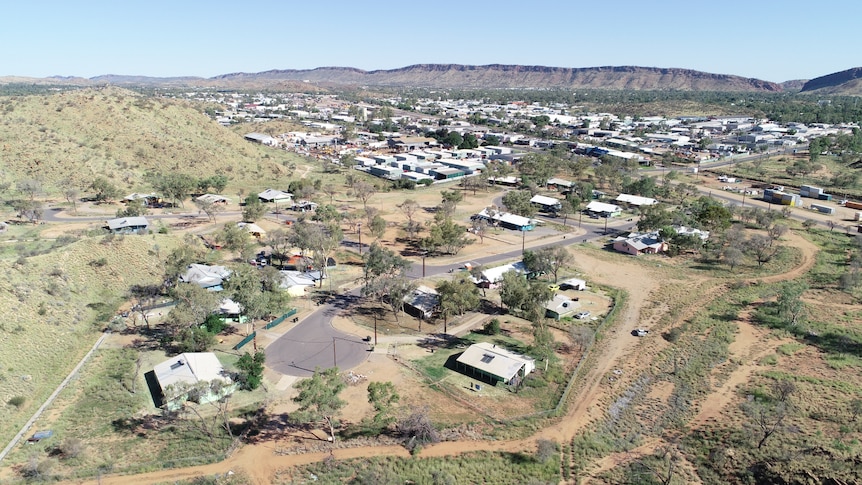 An aerial view of the Alice Springs township and its town camps, on a sunny day. 