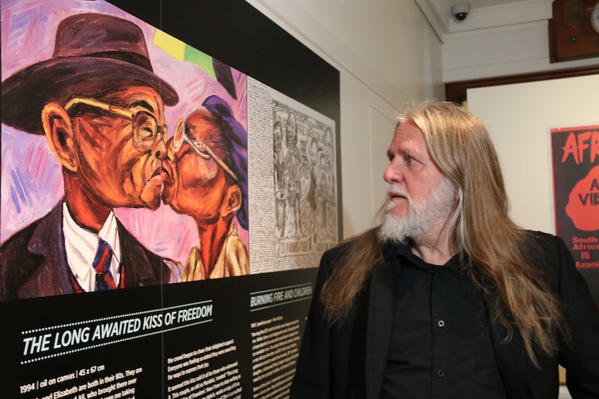 George Gittoes with a copy of his drawing 'The Long Awaited Kiss of Freedom', 27 April 2016