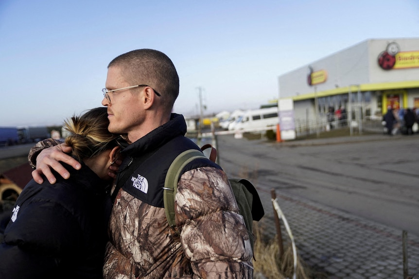 A couple embrace on the Polish Ukrainian border
