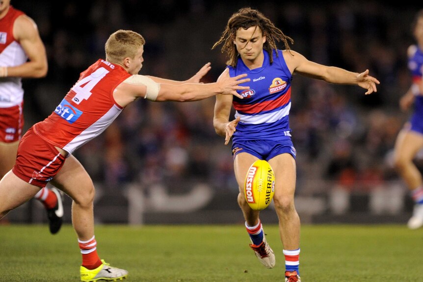 Sydney's Daniel Hannebery attempts to tackle Western Bulldogs' Luke Dahlhaus.