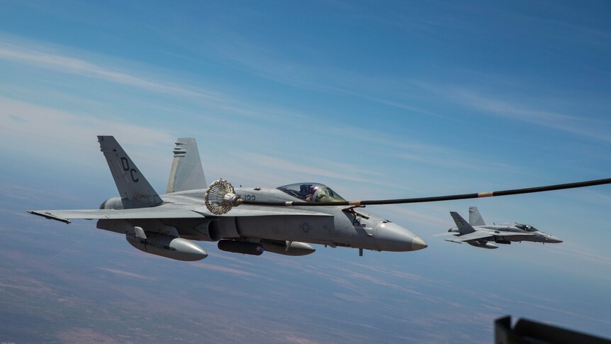 FA-18 Hornet refuels mid-air with KC-130