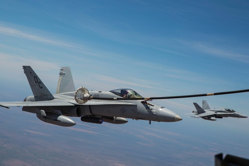 FA-18 Hornet refuels mid-air with KC-130