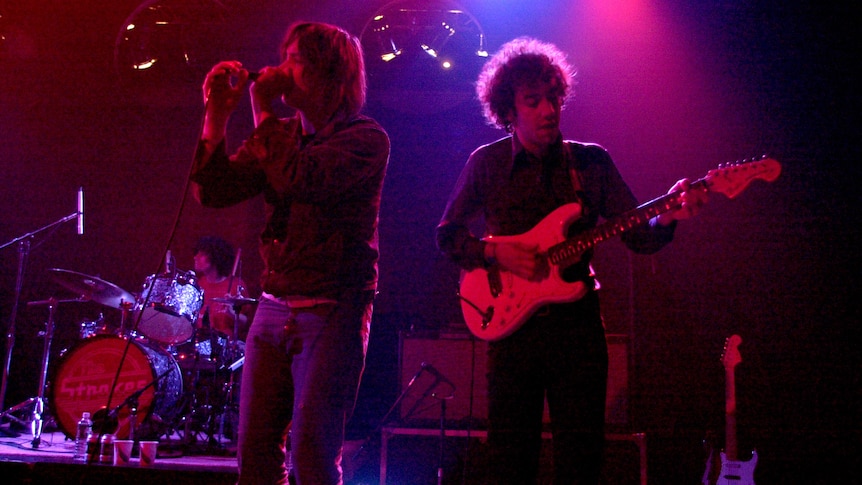 The Strokes performing on a dimly lit stage