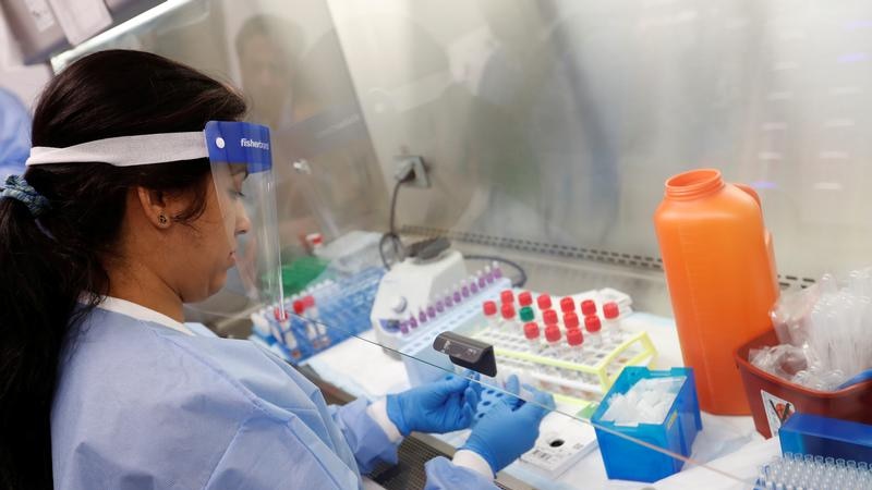 A medical technologist examining tests.