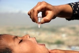 An Afghan child receives a dose of an oral polio vaccine