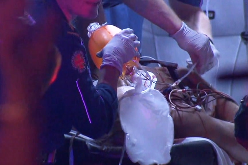 Paramedics work to save Dominik Schulze's life as he lies on a gurney.