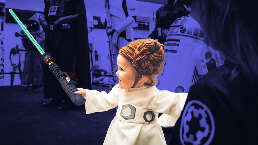 A little girl dressed as Princess Leia from Star Wars, with a blue lightsaber superimposed into her hand
