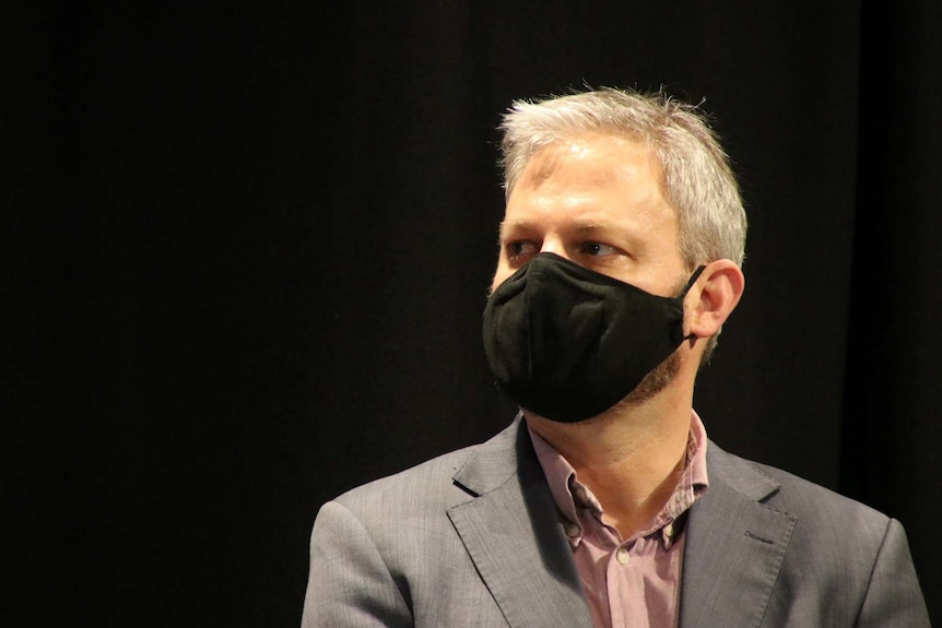 Chief Health Officer Brett Sutton wears a black face mask.