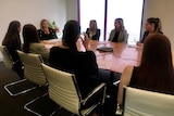 A group of women sitting around a table at a law firm