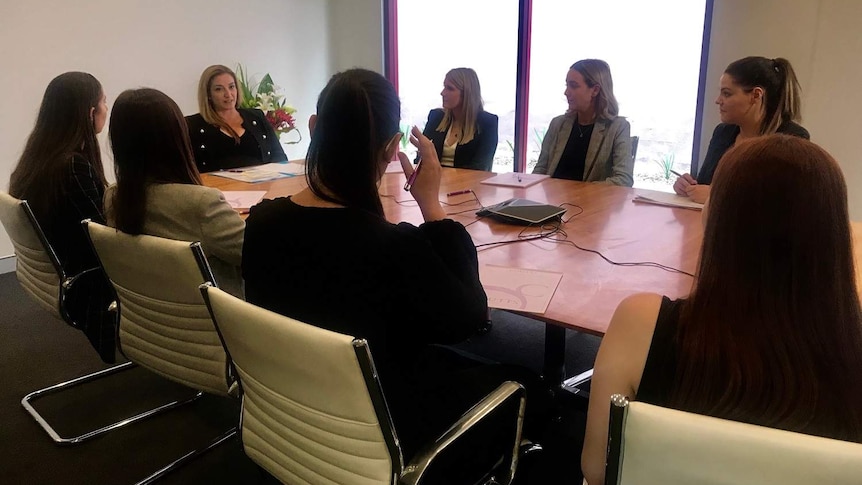 A group of women sitting around a table at a law firm