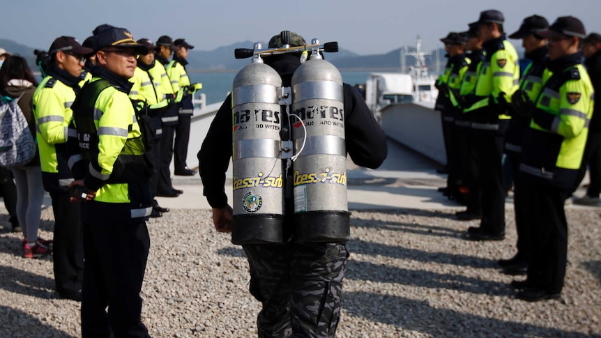 A diver walks to towards the water in the search for victims