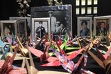 Paper cranes and photos of Japanese submarine crew who died