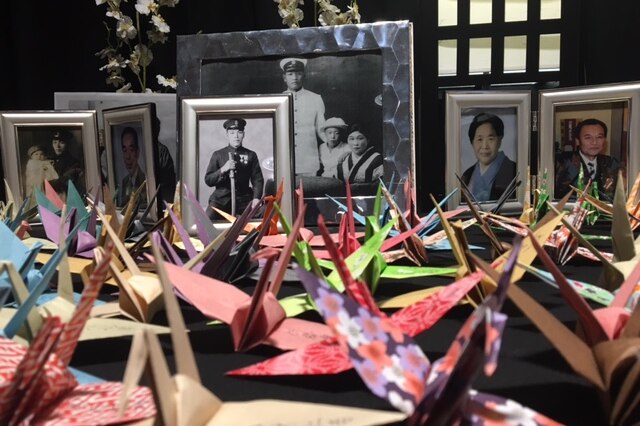 Paper cranes and photos of Japanese submarine crew who died