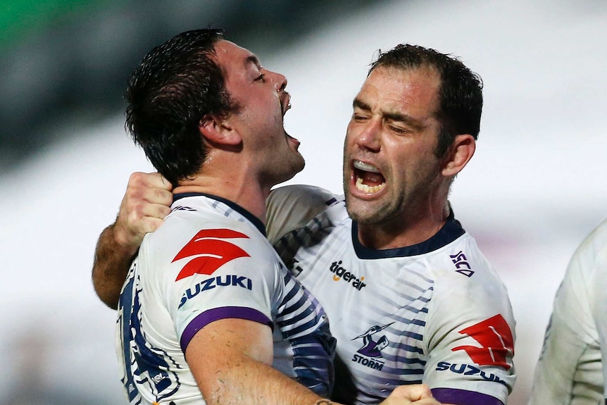 Brandon Smith and Cameron Smith shout as they hug during the Melbourne Storm's NRL win over the Newcastle Knights.