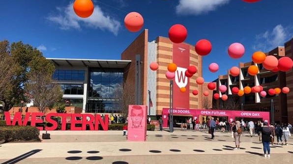 An exterior of a building decorated with balloons and bunting.