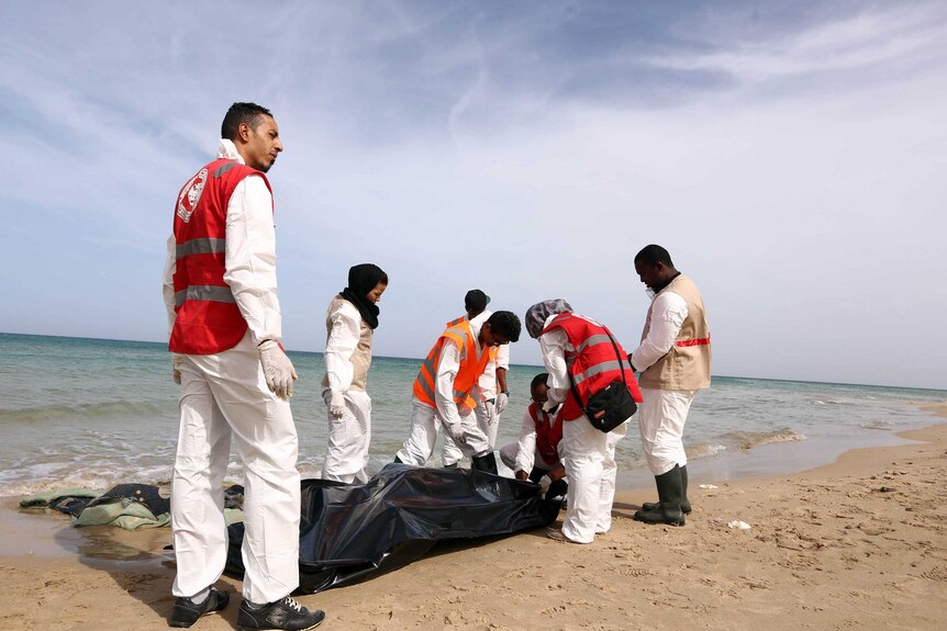 Members of the Red Crescent remove six bodies from a beach in Libya