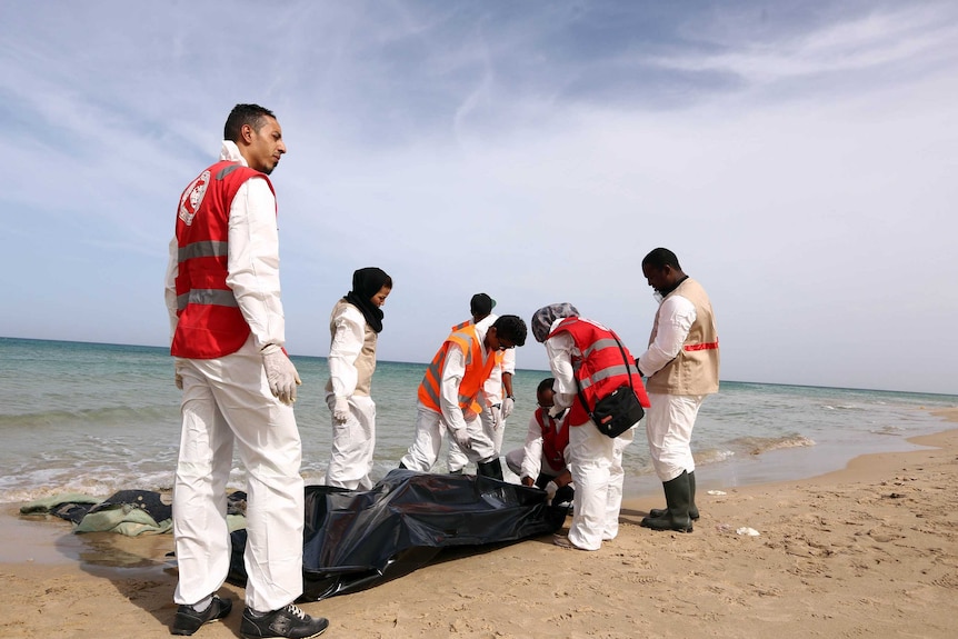 Members of the Red Crescent remove six bodies from a beach in Libya