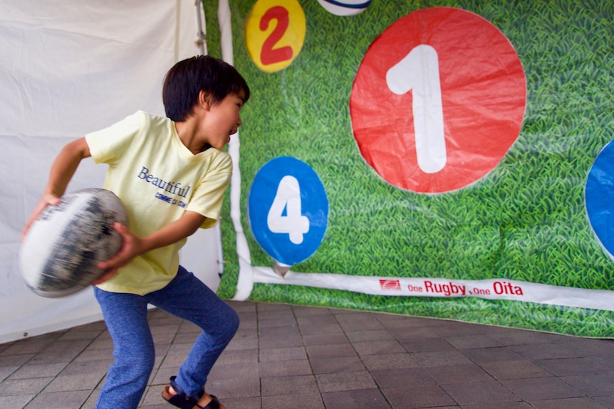 A child throws a ruby ball.