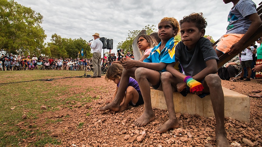 Aboriginal children wait during a speech by Warren Snowdon at the Wave Hill Walk-off 50th anniversary ceremony.